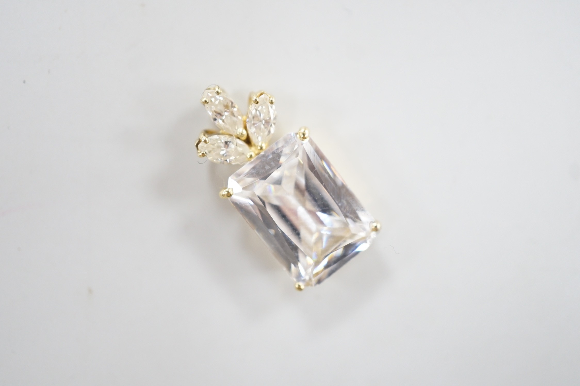 A modern yellow metal mount single stone simulated diamond and three stone diamond set pendant, 21mm, gross weight 4.2 grams.
